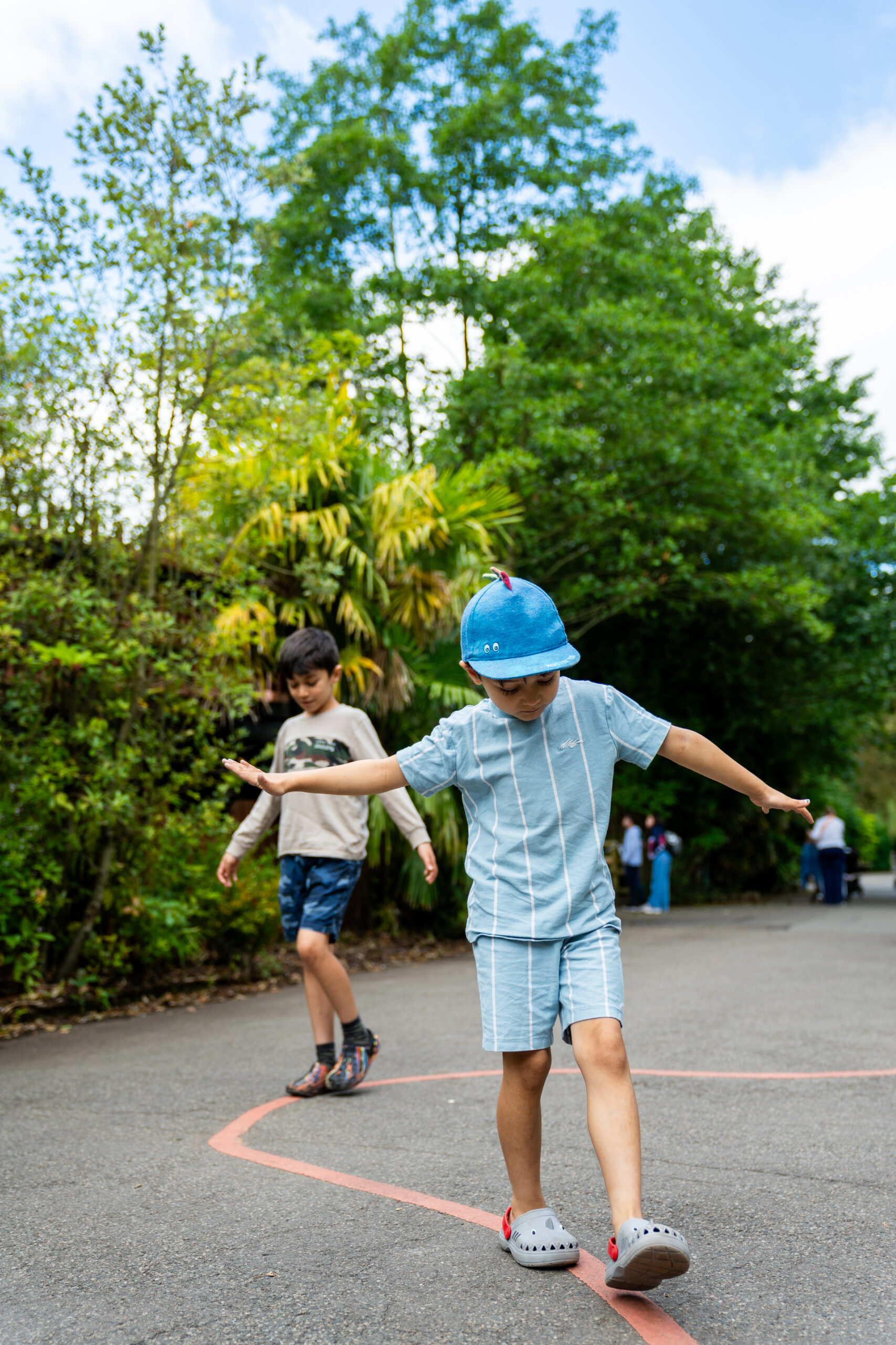 Young Boys Walking Along A Line Painted On The Ground