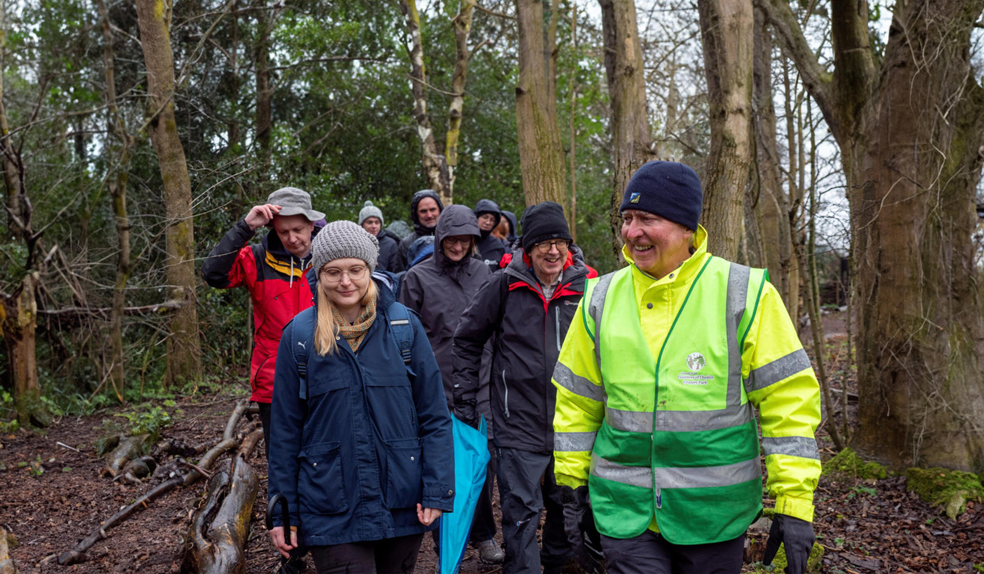 A group of people walking through a forest in the rain